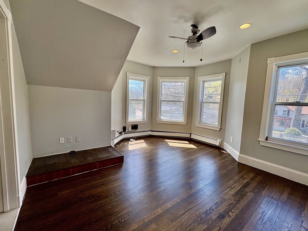 980 Washington Street, Unit 2 Stoughton, MA 02072 - Photo 4 of 10 an empty room with wooden floor and windows