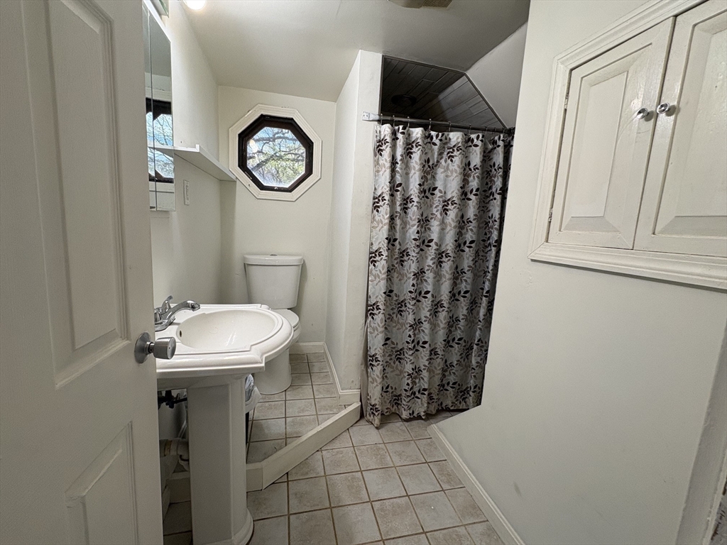 980 Washington Street, Unit 2 Stoughton, MA 02072 - Photo 5 of 10 a bathroom with a sink a toilet and a shower