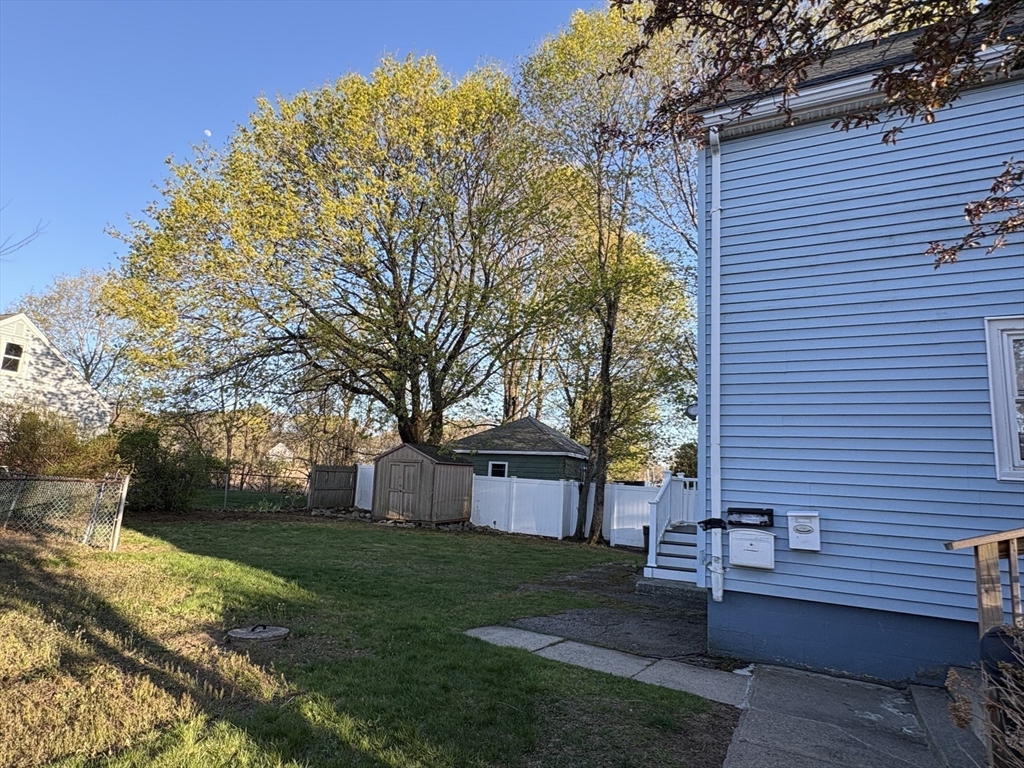 980 Washington Street, Unit 2 Stoughton, MA 02072 - Photo 10 of 10 a front view of a house with a garden and tree