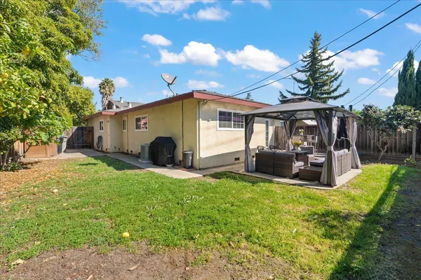 a view of a house with backyard porch and sitting area