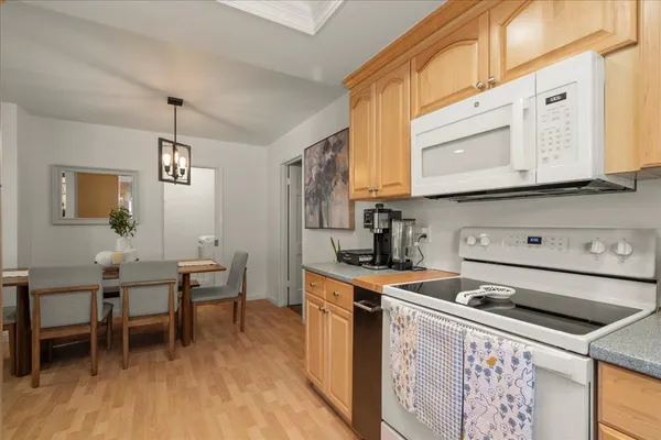 a kitchen with stainless steel appliances a stove a sink cabinets and a dining table