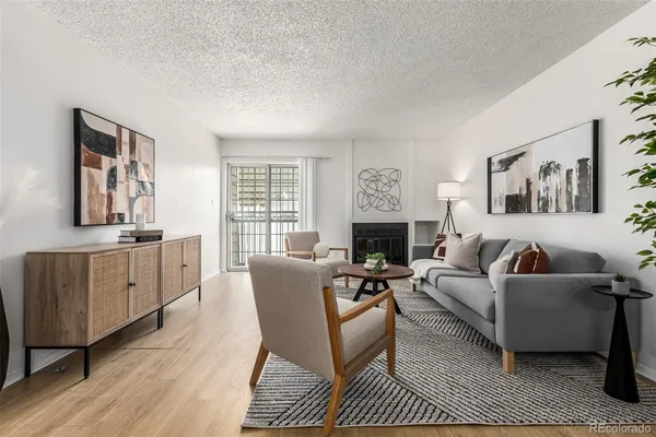 a living room with furniture a fireplace a flat screen tv and a window