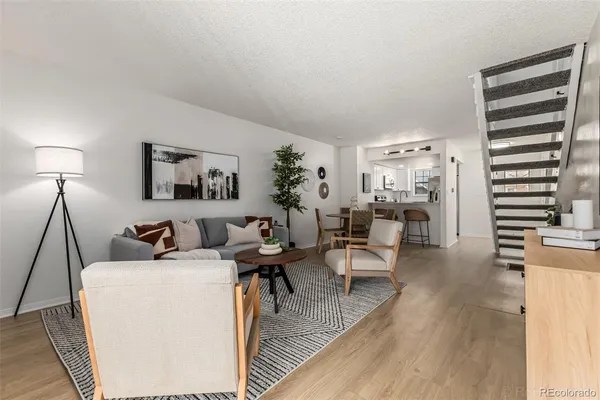 a living room with furniture a lamp and a wooden floor
