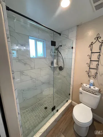 a bathroom with a toilet and a shower