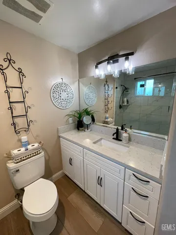 a bathroom with a toilet a sink and mirror