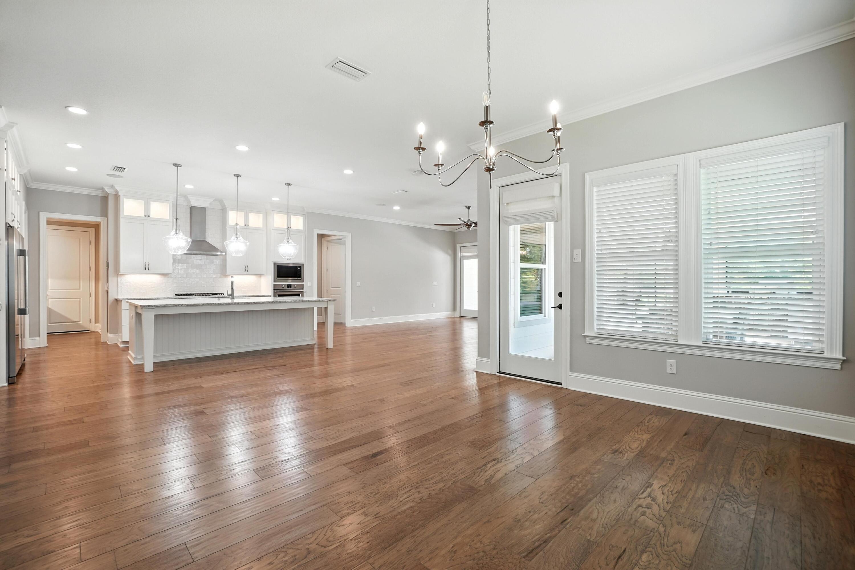 396 Revana Way Freeport, FL 32439 - Photo 11 of 68 a view of an empty room with wooden floor and a kitchen