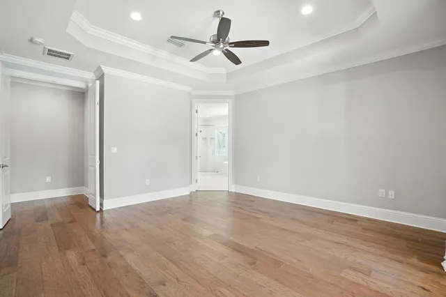 a view of hallway with walk in closet and wooden floor