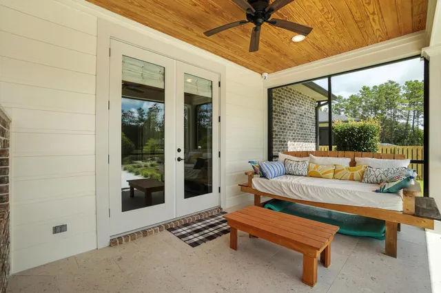 a front view of a house with swimming pool and porch with furniture