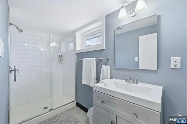 a bathroom with a shower a sink and mirror