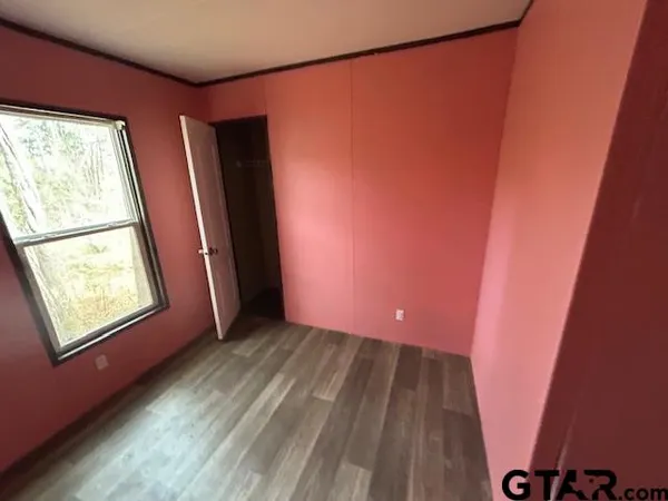 a view of hallway with window and wooden floor