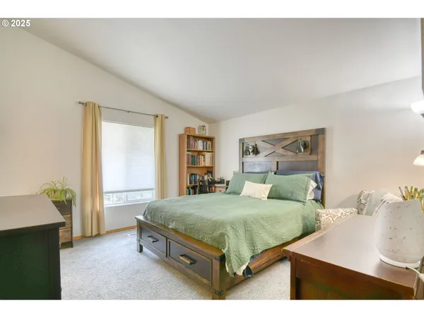 a bedroom with a bed a table and painting on the wall