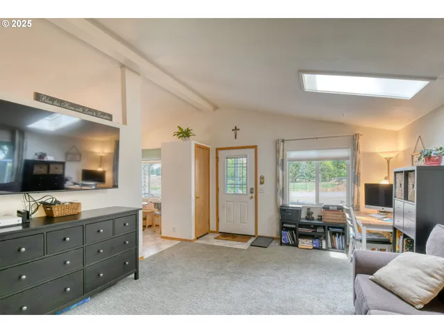 a living room with furniture flat screen tv and large window
