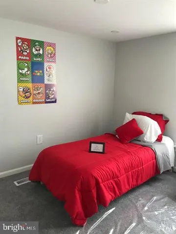 a bedroom with a bed and a painting on the wall