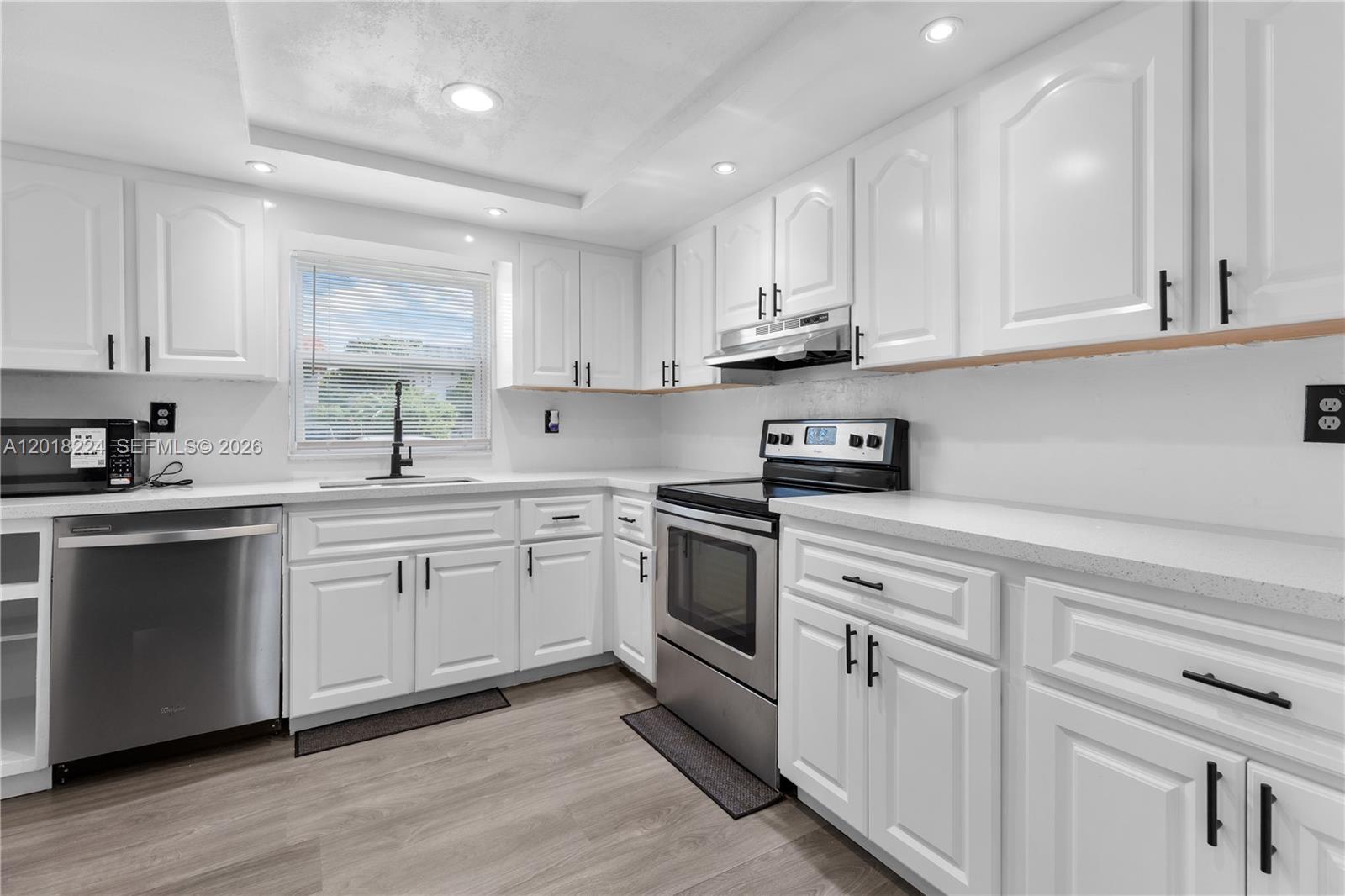 7958 Southwest 6th Street Pompano Beach, FL 33068 - Photo 17 of 57 a kitchen with white cabinets sink and appliances