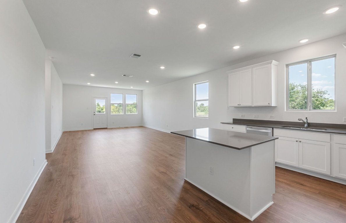 3003 Gillespie Court Temple, TX 76501 - Photo 3 of 17 a open kitchen with kitchen island a sink dishwasher a stove and a refrigerator with wooden floor