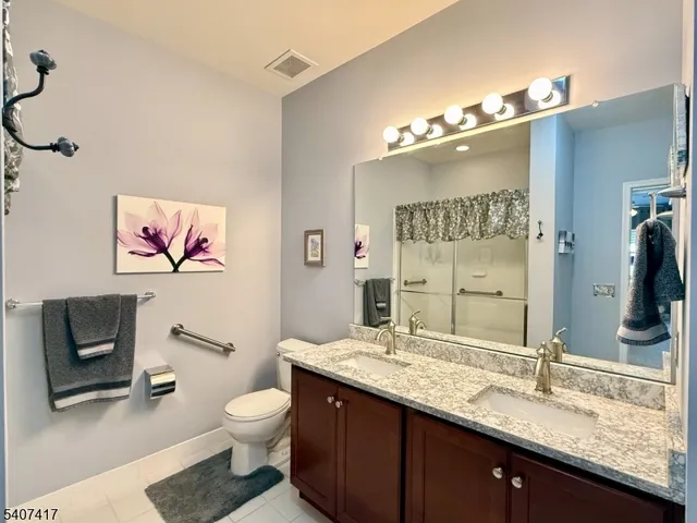 a bathroom with a granite countertop toilet a sink and a mirror