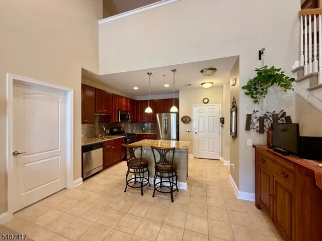 a kitchen with granite countertop refrigerator and dining table
