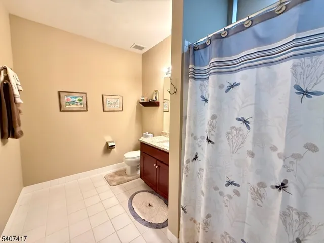 a bathroom with a granite countertop toilet and a shower