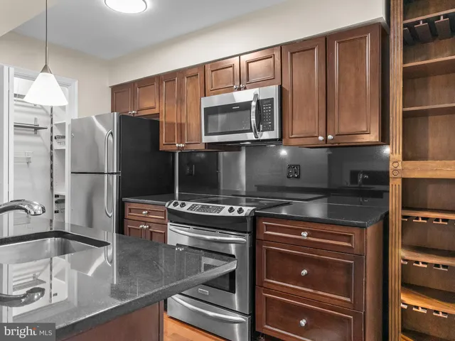 a kitchen with stainless steel appliances granite countertop a refrigerator and a stove top oven
