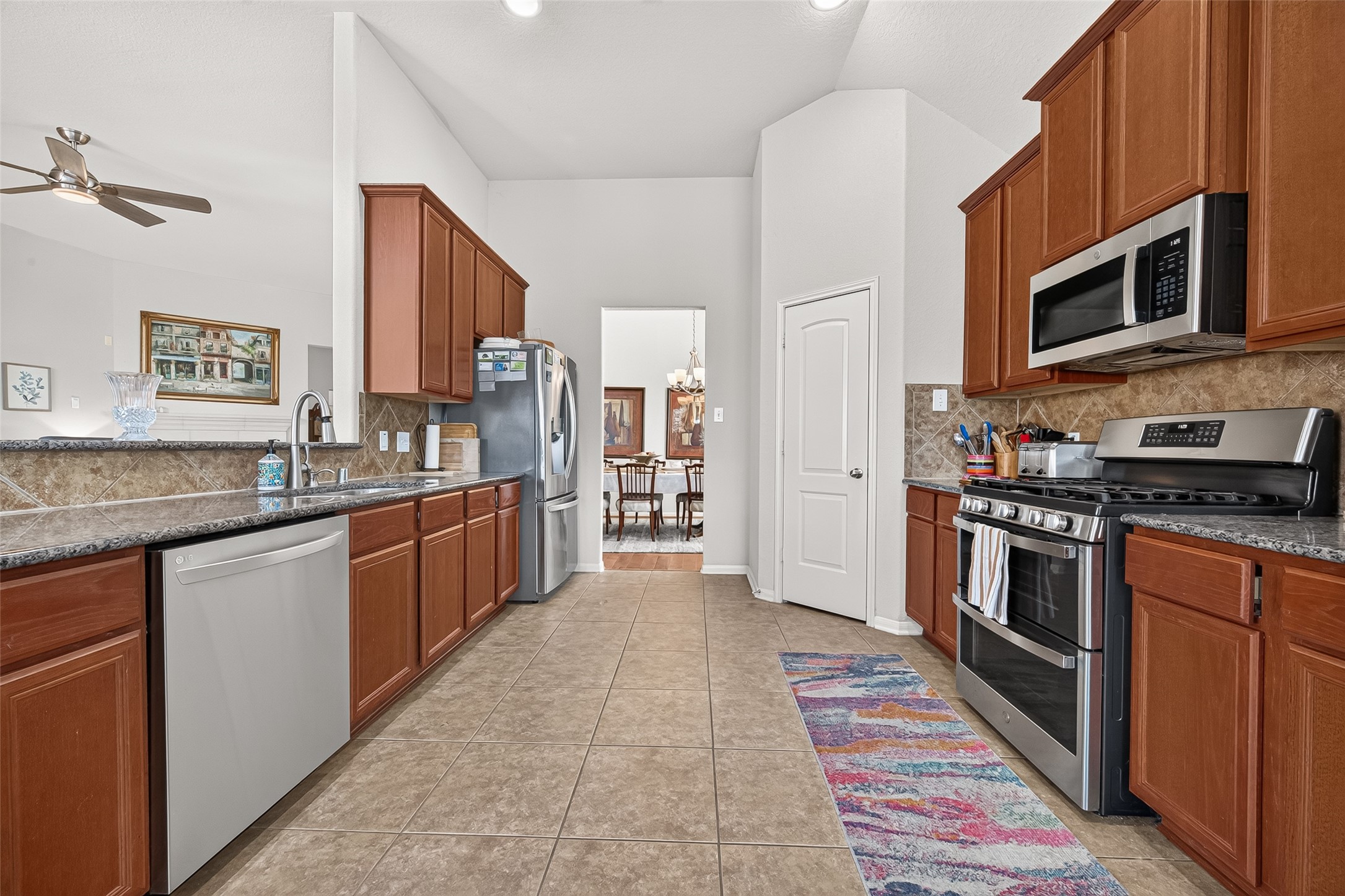 4910 Culver Lane Rosenberg, TX 77471 - Photo 27 of 50 The kitchen is spacious, with gorgeous GRANITE countertops, and ample 42" wooden cabinetry. It features tiled flooring and opens to a dining area, creating a seamless flow for entertaining.