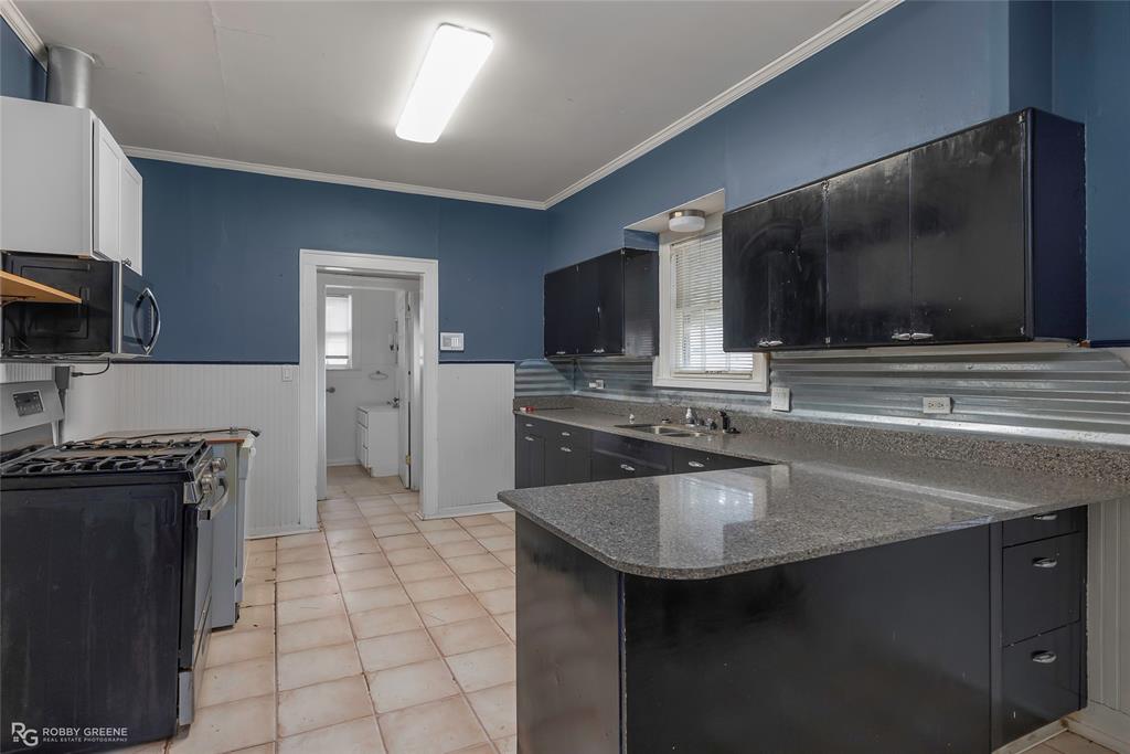 117 Merrick Street Shreveport, LA 71104 - Photo 14 of 25 a kitchen with kitchen island a sink stove top oven and microwave