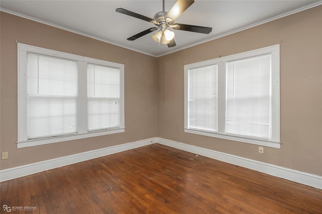 117 Merrick Street Shreveport, LA 71104 - Photo 21 of 25 an empty room with wooden floor ceiling fan and windows