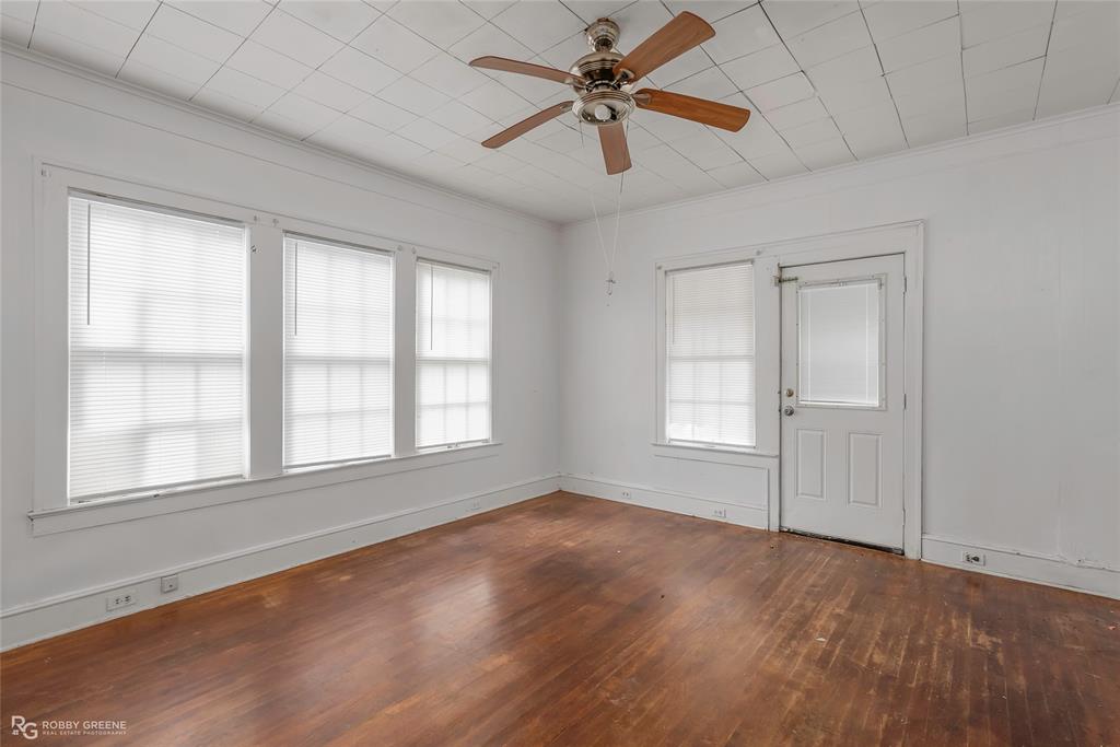 117 Merrick Street Shreveport, LA 71104 - Photo 25 of 25 an empty room with wooden floor chandelier fan and windows