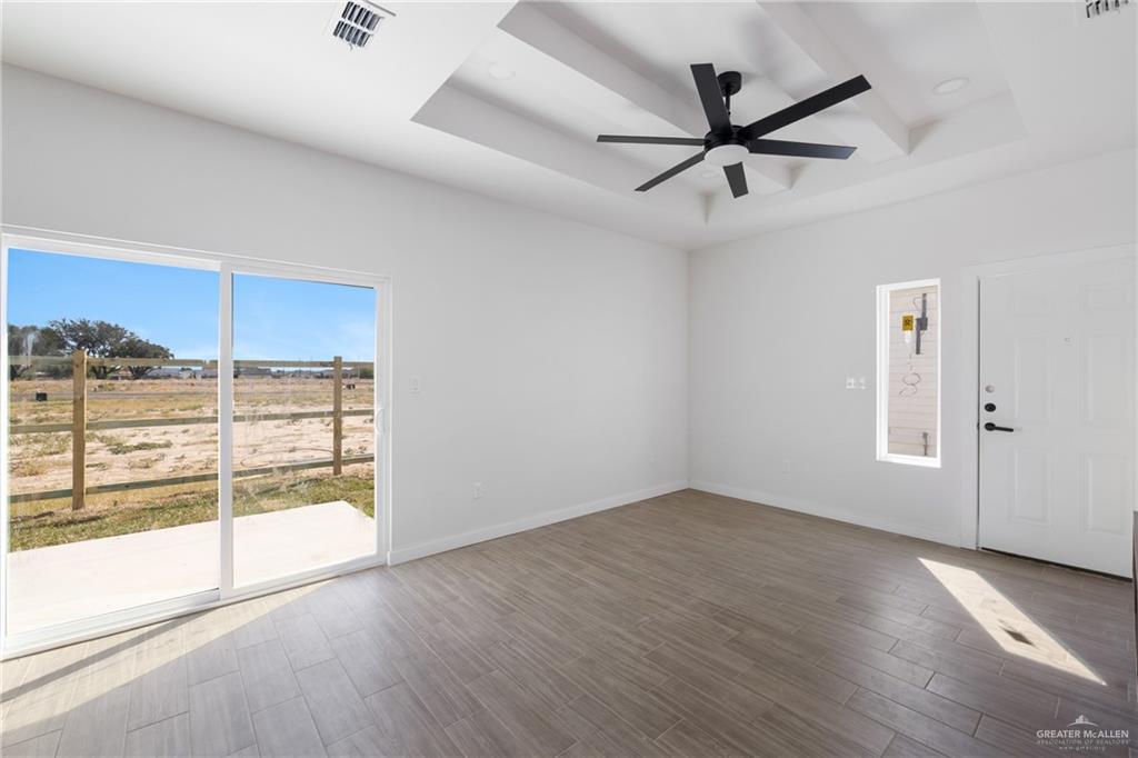 2902 Gabriel Street, Unit 2 Mission, TX 78574 - Photo 5 of 13 an empty room with wooden floor fan and windows