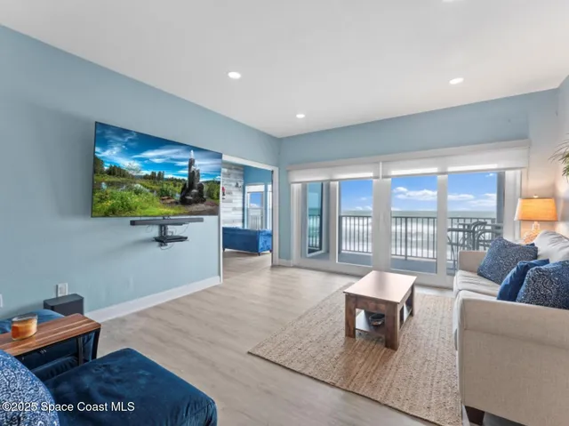 a living room with furniture and a floor to ceiling window