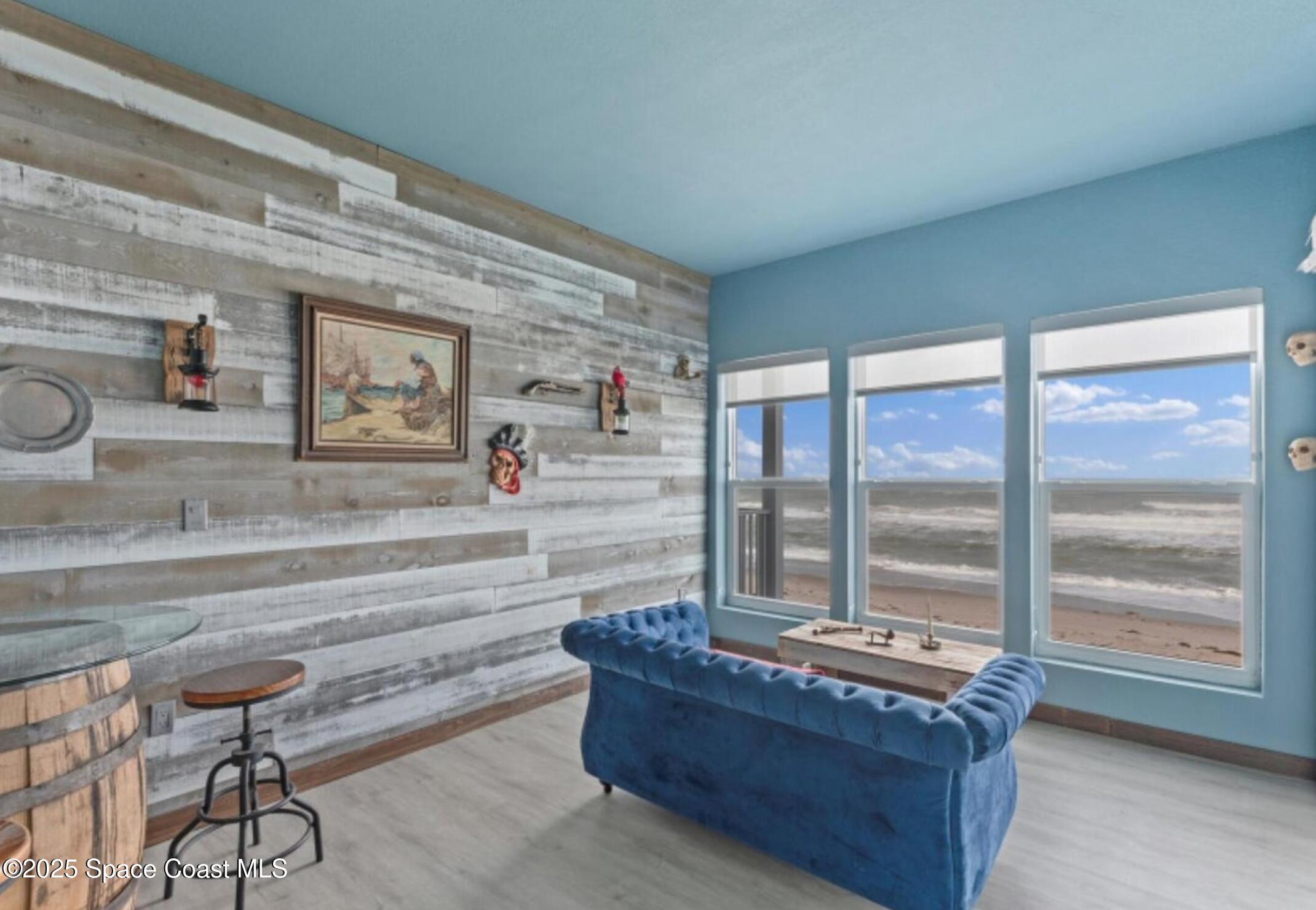 3037 S Highway, Unit 2C Melbourne Beach, FL 32951 - Photo 14 of 48 a living room with furniture and a floor to ceiling window