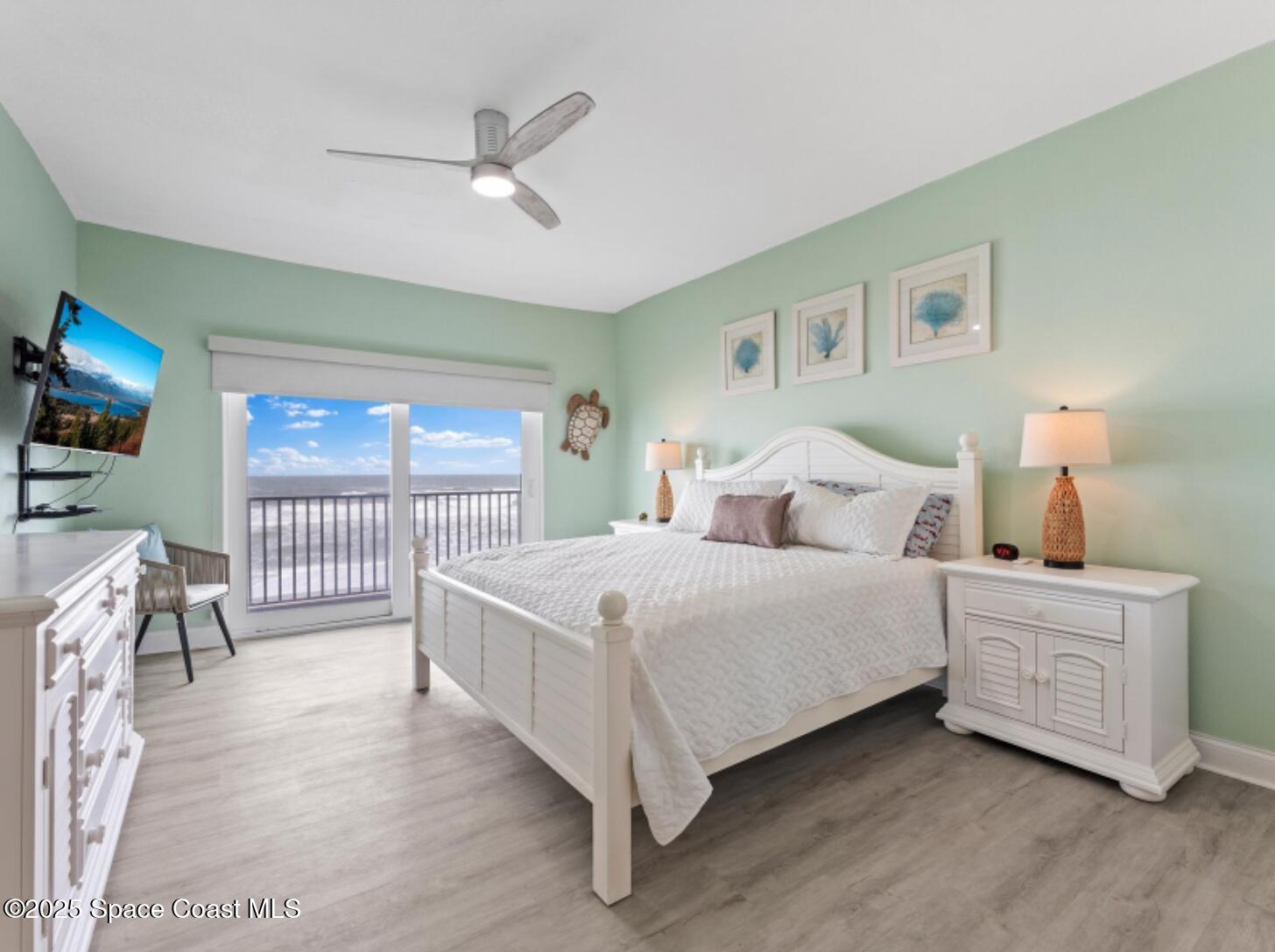 3037 S Highway, Unit 2C Melbourne Beach, FL 32951 - Photo 17 of 48 a bedroom with a large bed and a chandelier