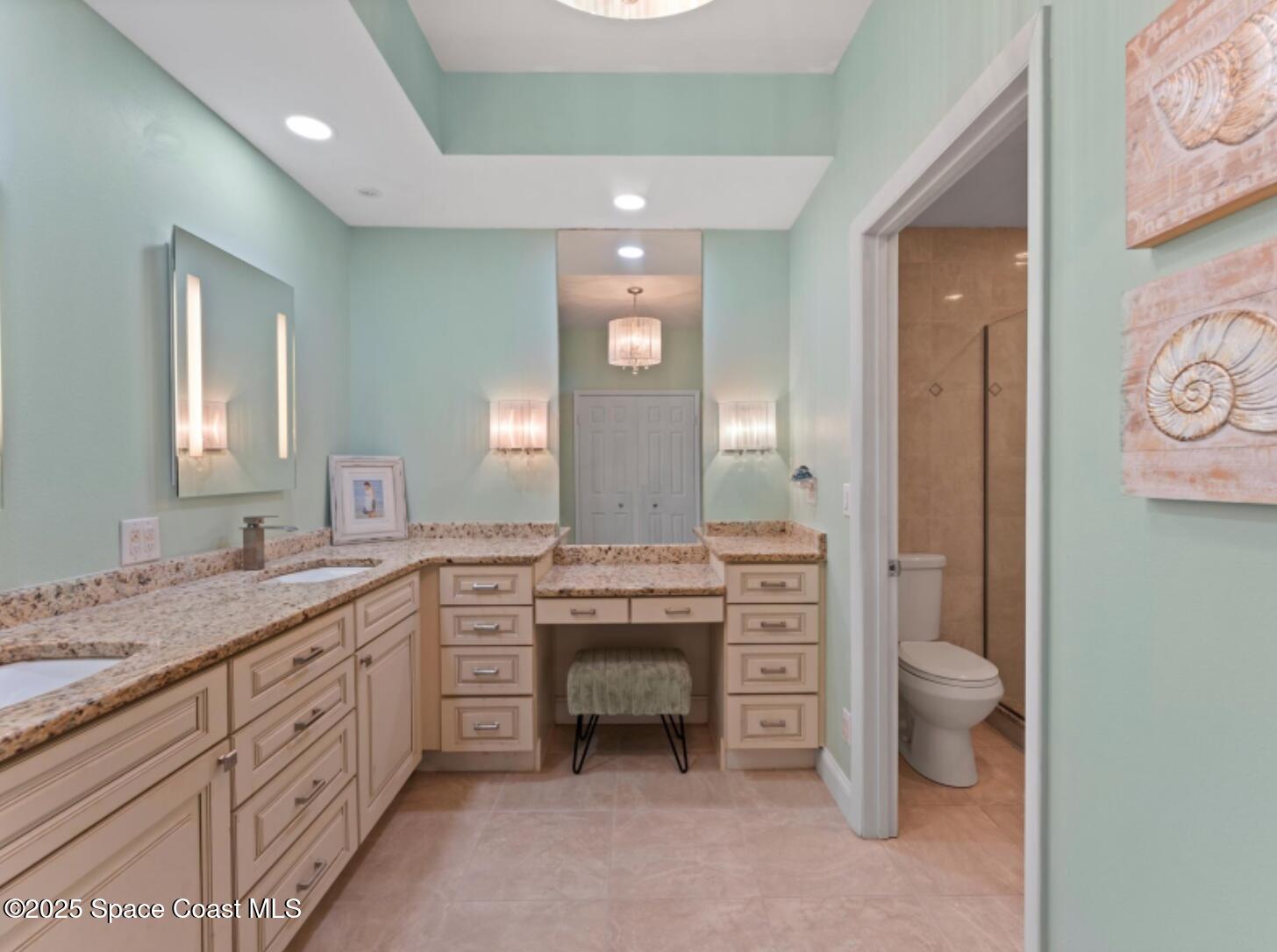 3037 S Highway, Unit 2C Melbourne Beach, FL 32951 - Photo 20 of 48 a spacious bathroom with a granite countertop sink a toilet and a mirror
