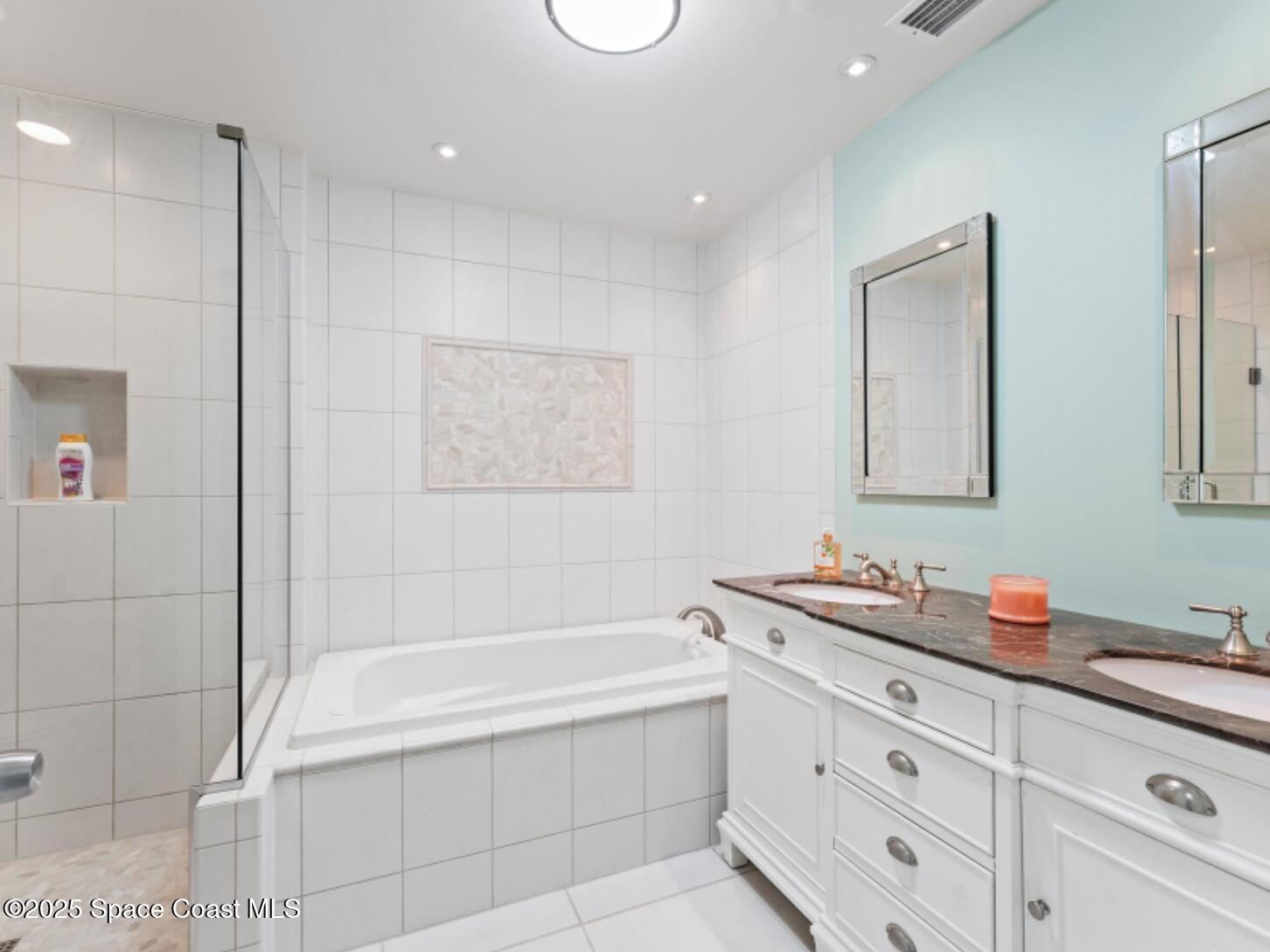 3037 S Highway, Unit 2C Melbourne Beach, FL 32951 - Photo 25 of 48 a bathroom with a tub sink and mirror