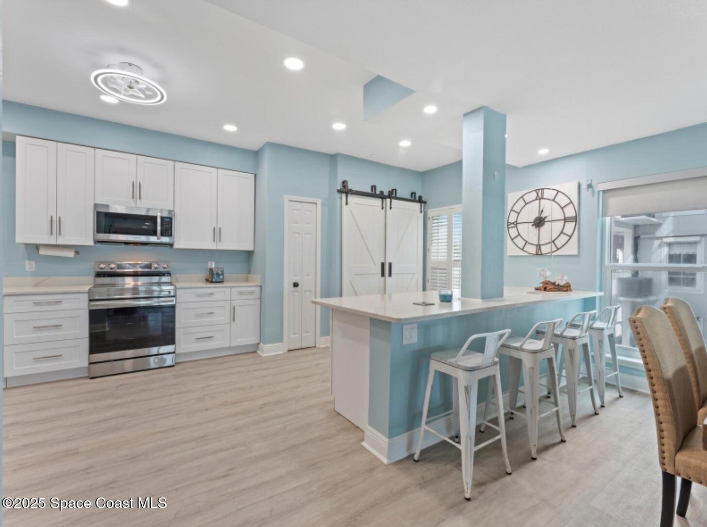 3037 S Highway, Unit 2C Melbourne Beach, FL 32951 - Photo 5 of 48 a kitchen with stainless steel appliances granite countertop a stove top oven a sink island and chairs