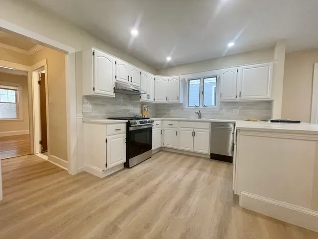 a kitchen with stainless steel appliances granite countertop a stove top oven a sink dishwasher and a refrigerator