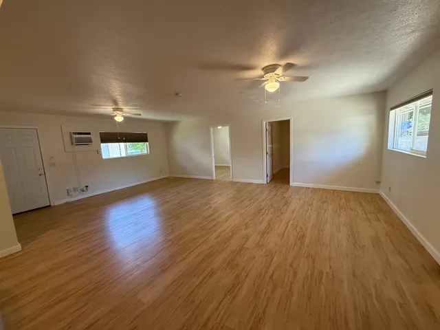 a view of a livingroom with wooden floor and a ceiling fan