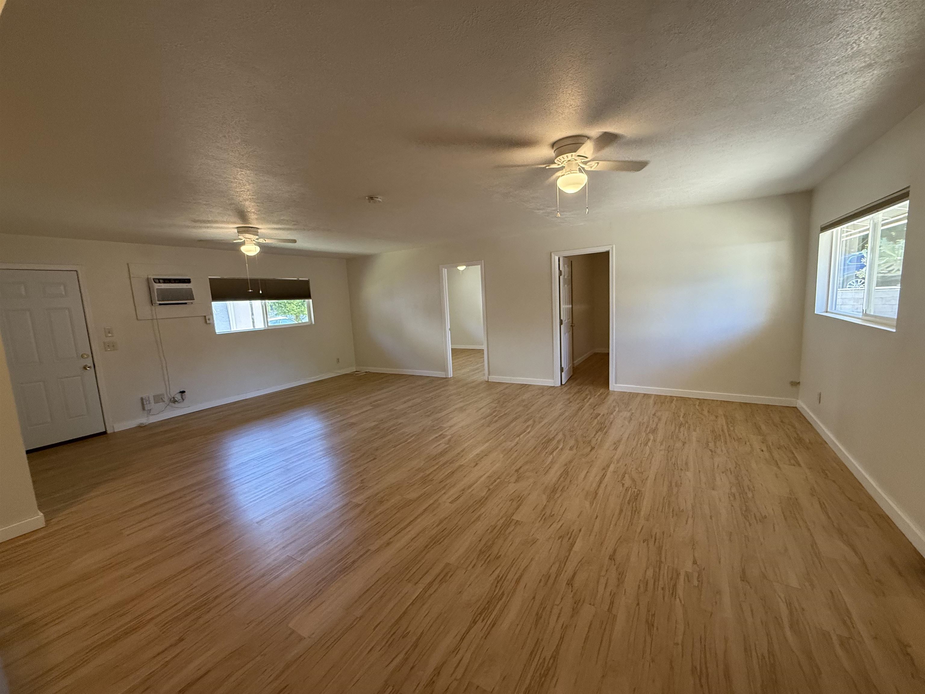 a view of a livingroom with wooden floor and a ceiling fan