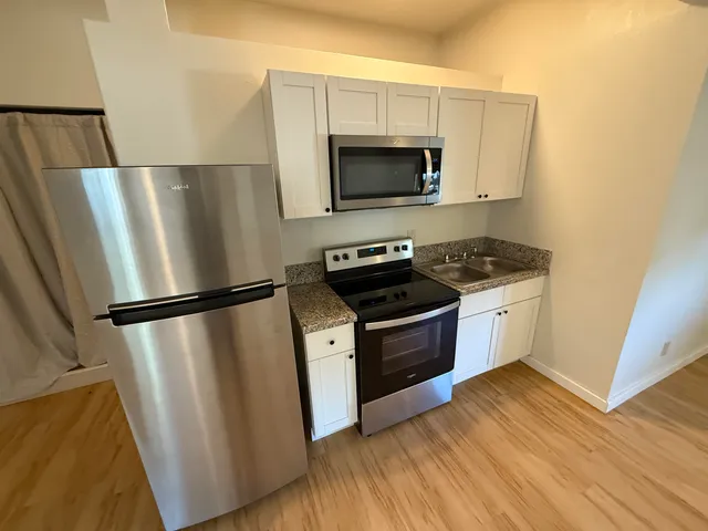 a kitchen with a refrigerator stove and microwave