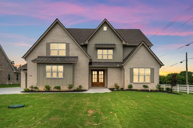 a front view of a house with a yard and trees