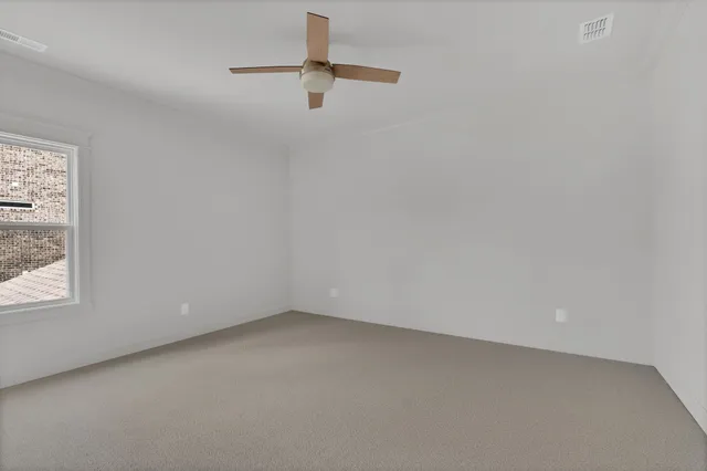 en empty room with windows and fan