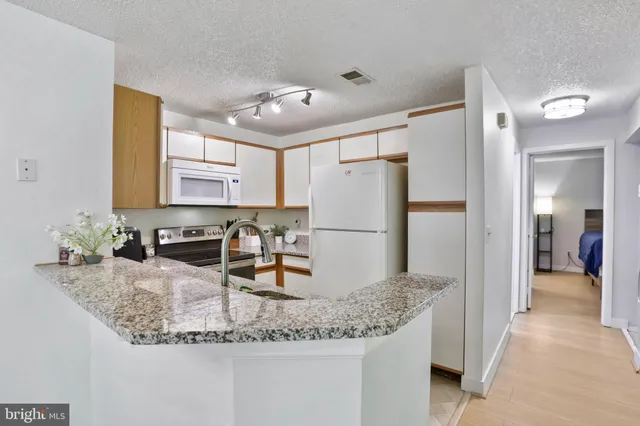 a kitchen with sink refrigerator and microwave