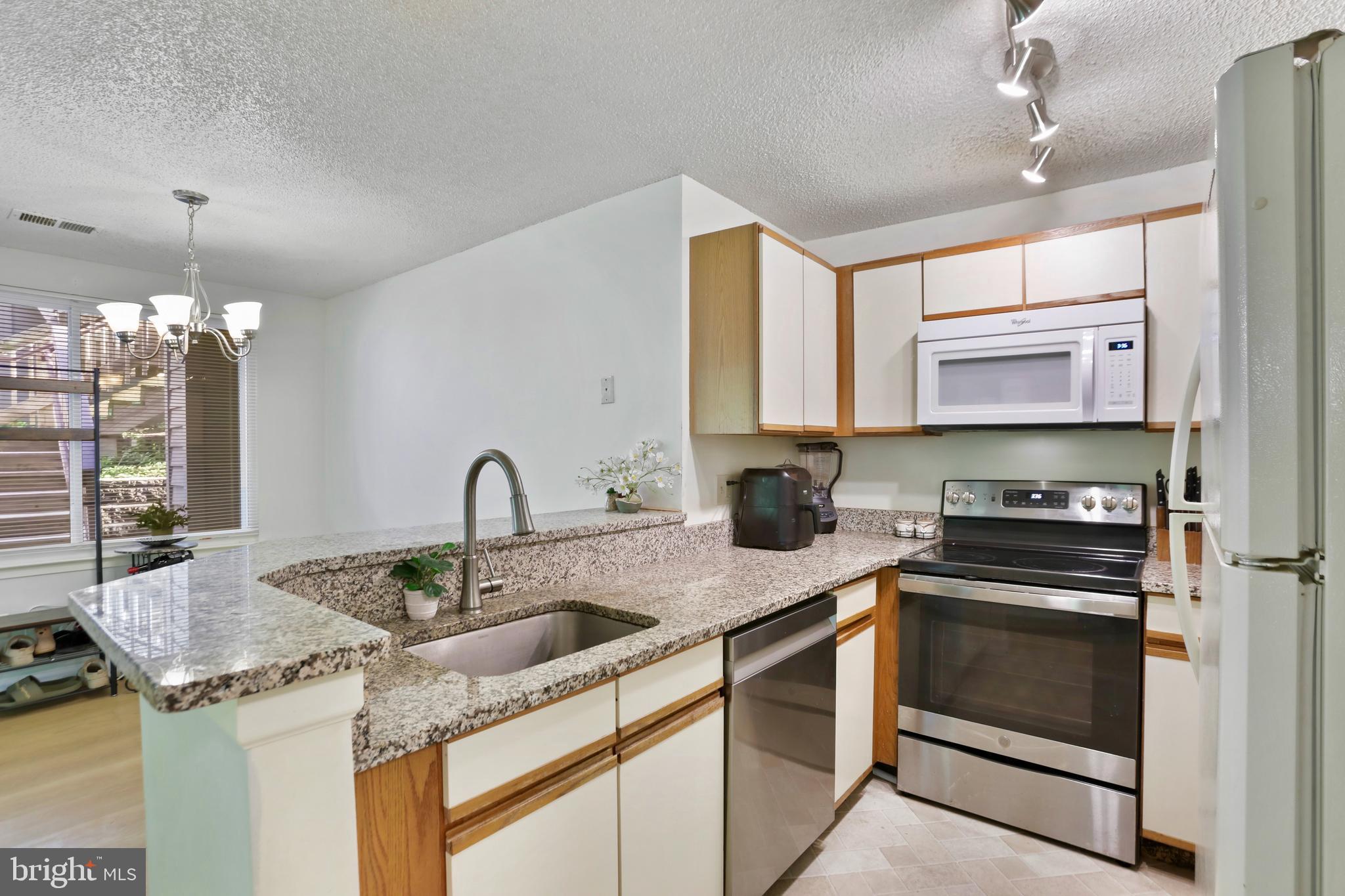 11723 Summerchase Circle Reston, VA 20194 - Photo 9 of 22 a kitchen with stainless steel appliances granite countertop a sink stove and cabinets