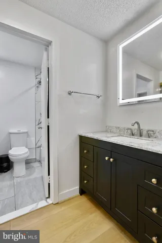 a spacious bathroom with a granite countertop sink toilet and shower