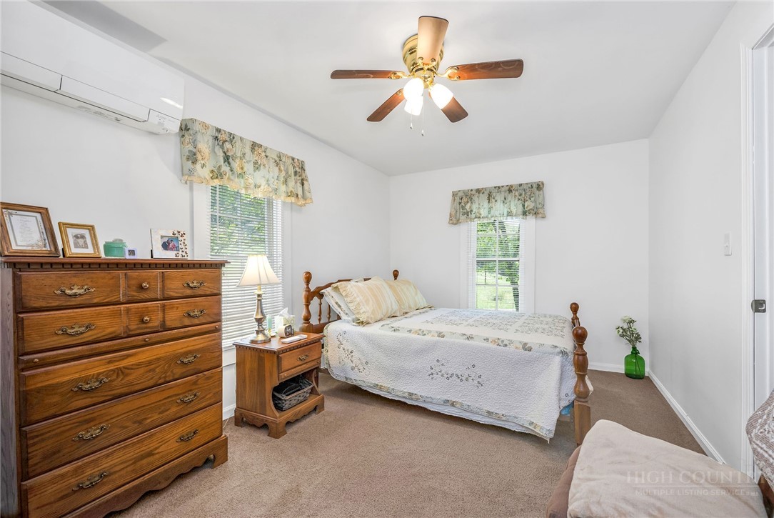 2284 Idlewild Road West Jefferson, NC 28694 - Photo 17 of 23 a bedroom with a bed and a chandelier