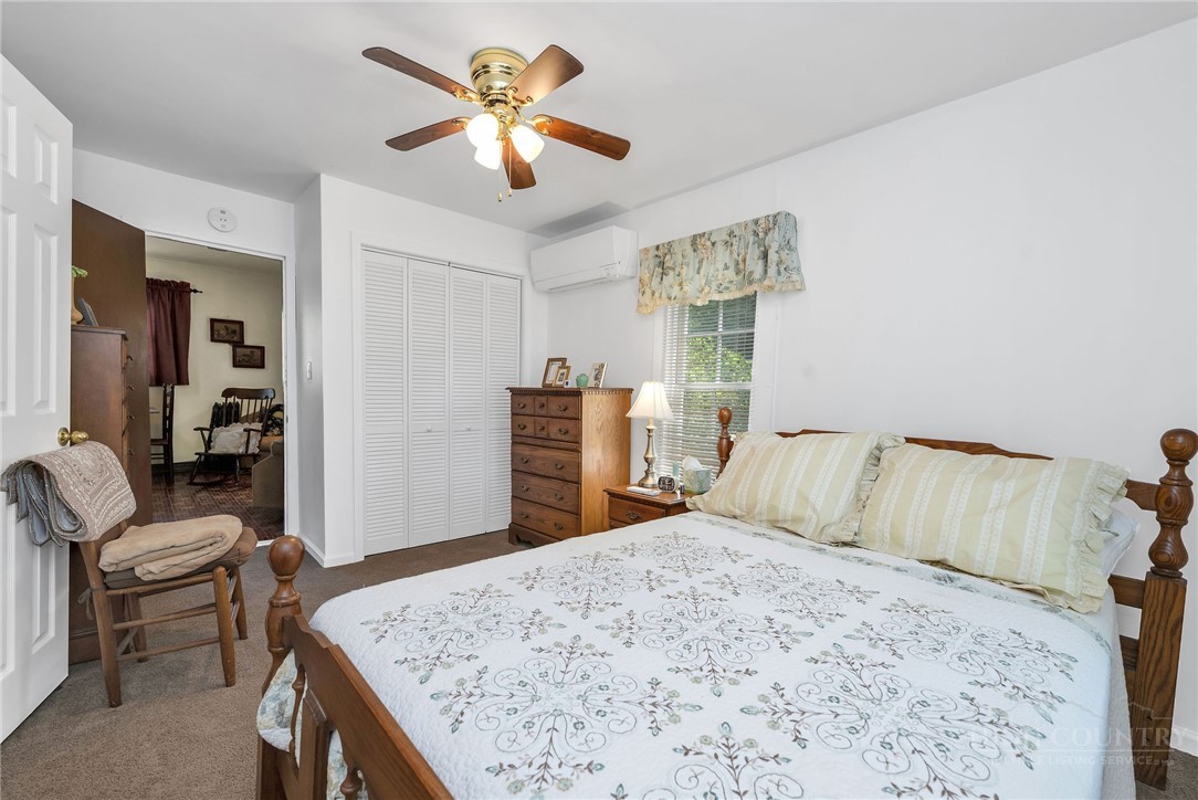 2284 Idlewild Road West Jefferson, NC 28694 - Photo 18 of 23 a bedroom with a bed a chair and potted plant on the dresser