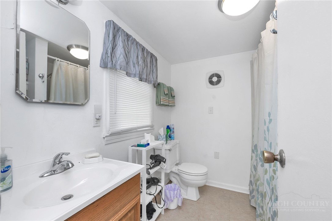2284 Idlewild Road West Jefferson, NC 28694 - Photo 21 of 23 a bathroom with a sink mirror vanity and toilet