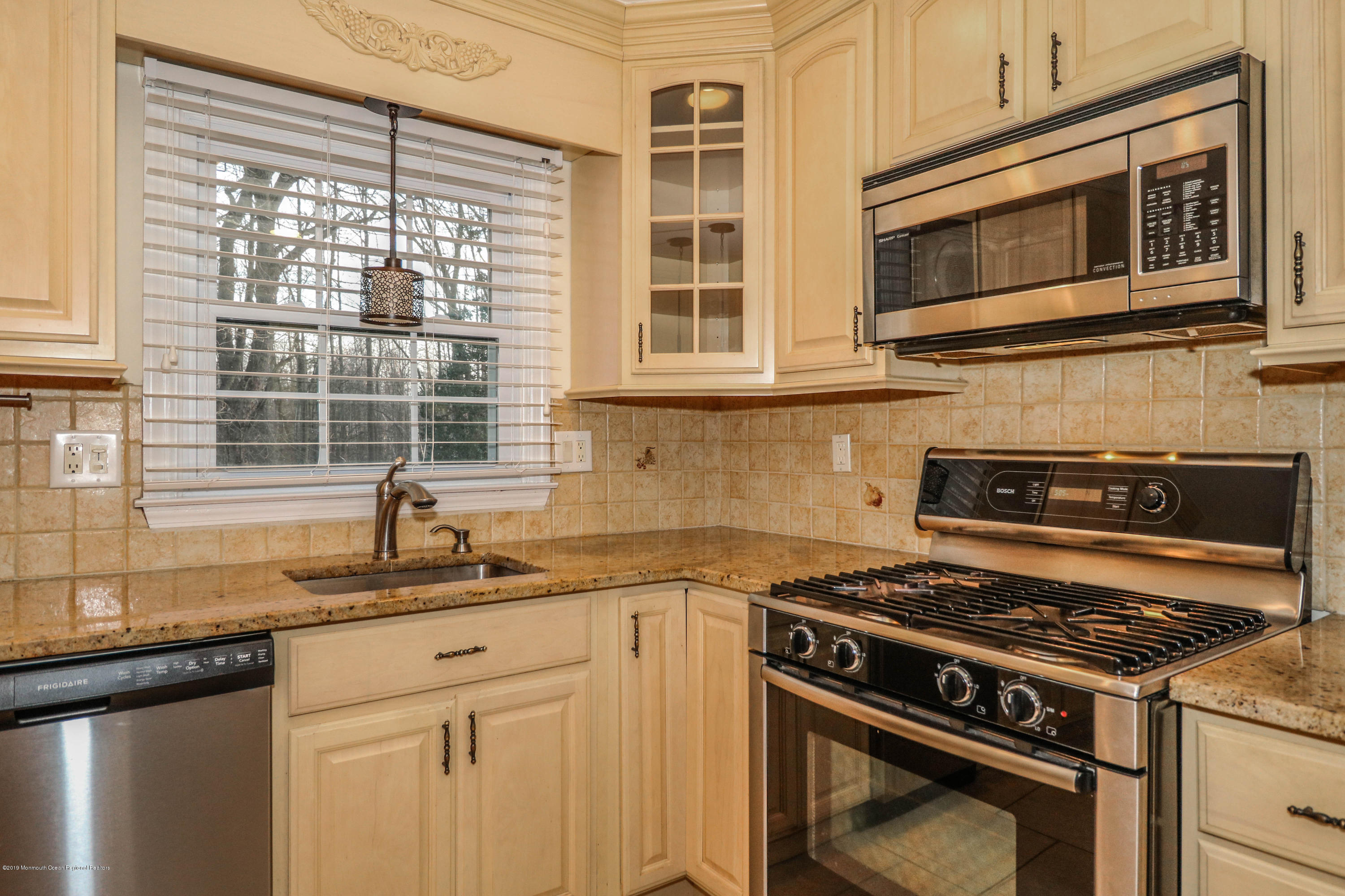 15 Middlebrook Drive Asbury Park, NJ 07712 - Photo 16 of 39 a kitchen with granite countertop a stove sink and microwave