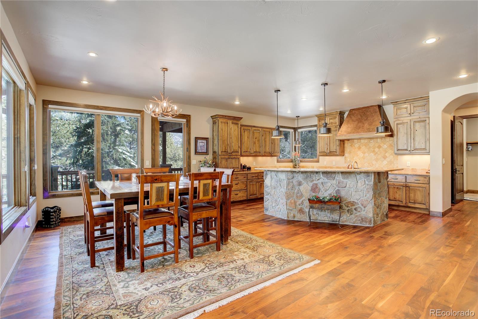 92 Whiskey Jay Hill Road Evergreen, CO 80439 - Photo 12 of 45 an open kitchen with granite countertop a stove dining table and chairs