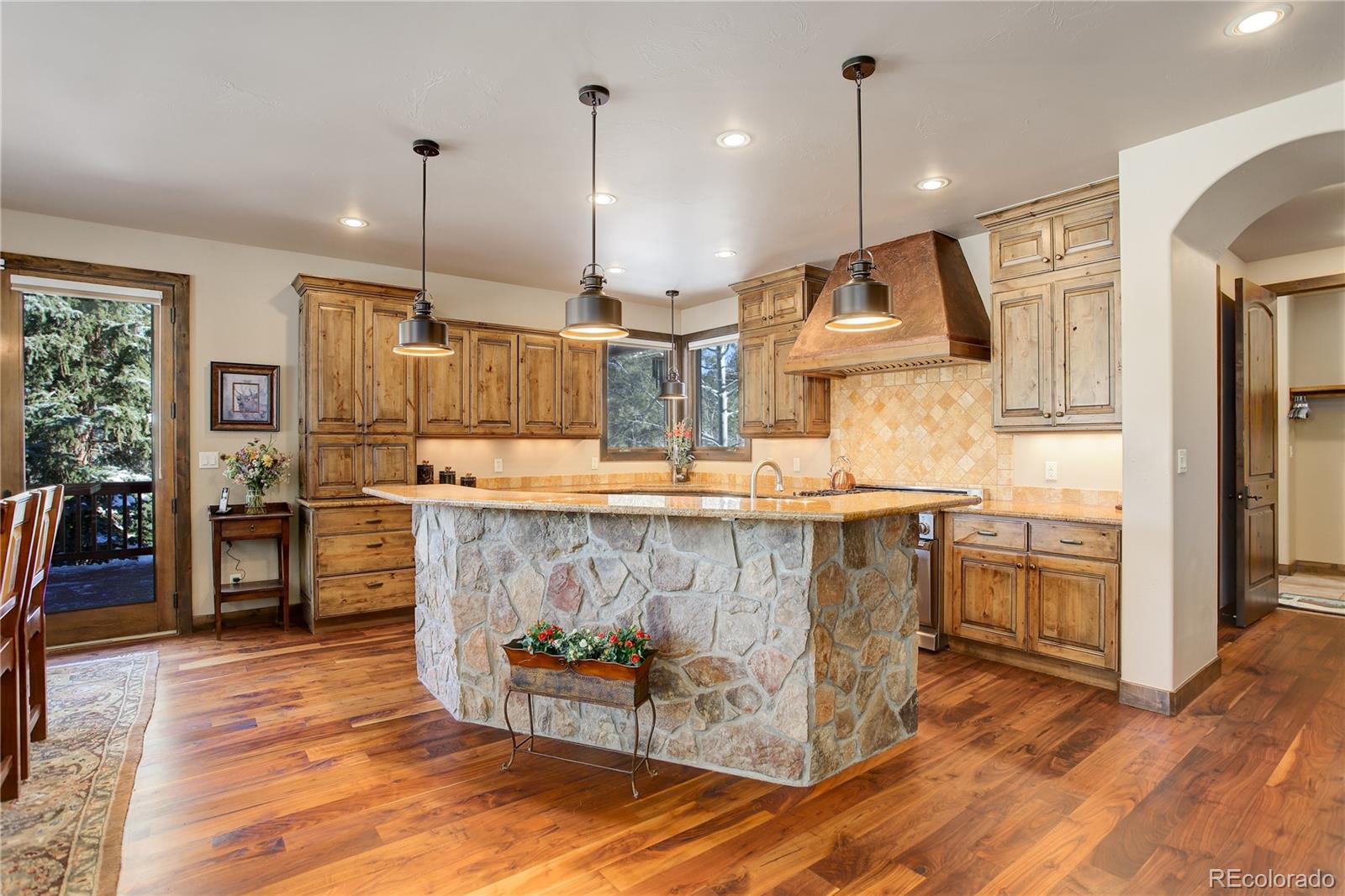 92 Whiskey Jay Hill Road Evergreen, CO 80439 - Photo 15 of 45 a kitchen with stainless steel appliances kitchen island granite countertop a stove a refrigerator and a wooden floor