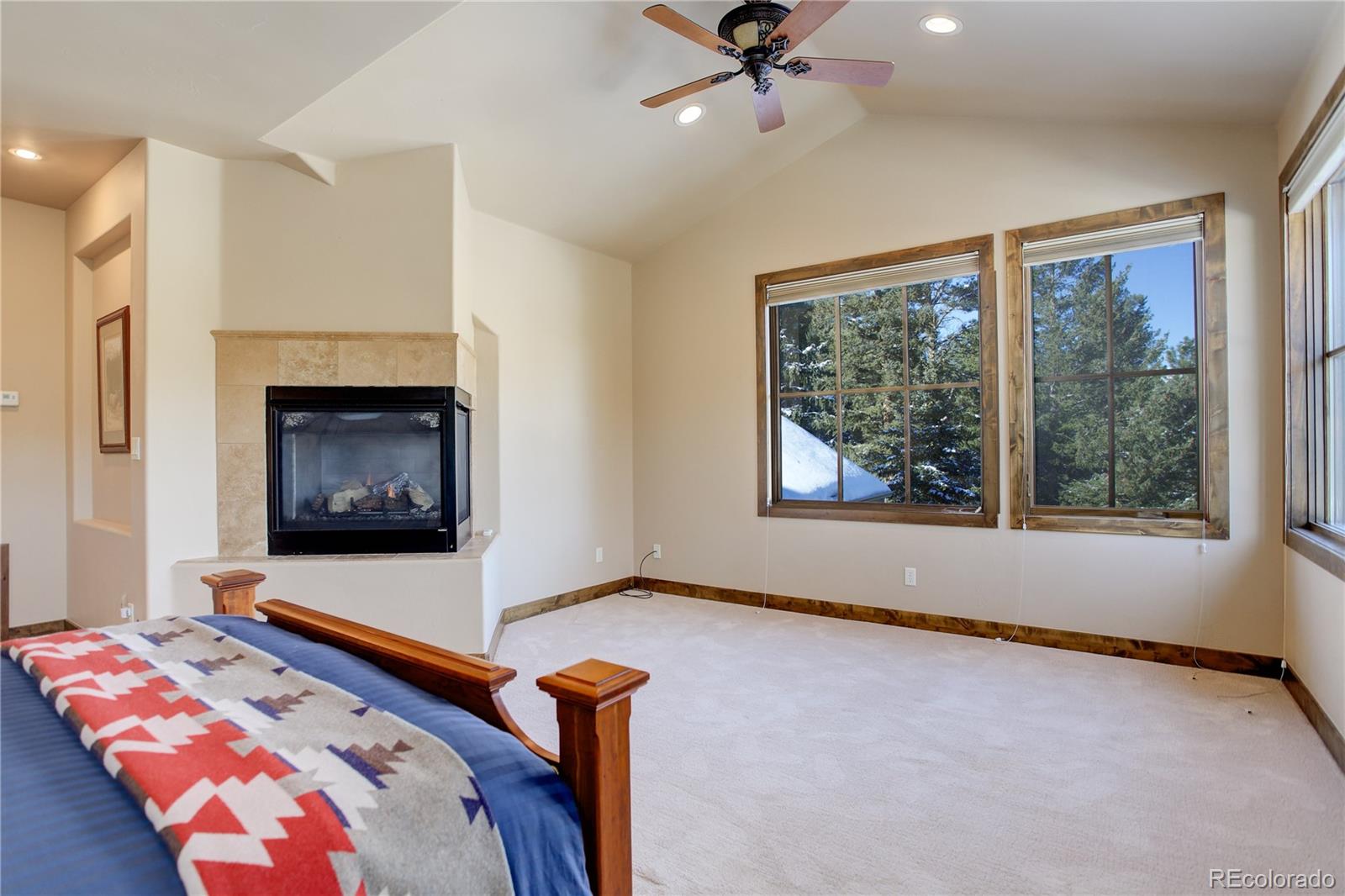 92 Whiskey Jay Hill Road Evergreen, CO 80439 - Photo 26 of 45 a bedroom with a bed and a fireplace